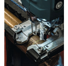 Nahaufnahme einer Stichsäge beim Schneiden eines Metallrohrs.