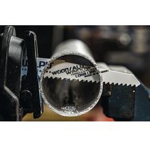 Metallsägeblatt schneidet ein Metallrohr in einer Halterung