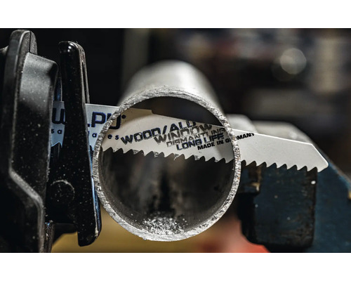 Metallsägeblatt schneidet ein Metallrohr in einer Halterung