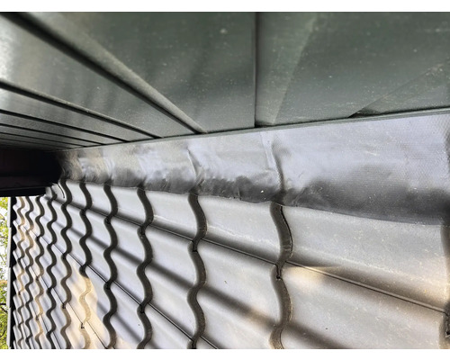 Detailansicht einer Dachkonstruktion mit Dachziegeln und Dachfolie