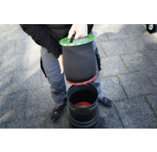 Person setzt Filtersack in eine Filtertonne
