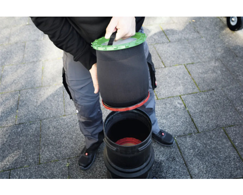 Person setzt Filtersack in einen Teichfilter ein