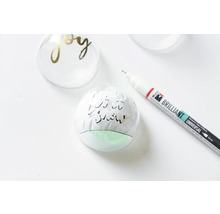 Dekorierte Weihnachtskugeln und ein Stift.