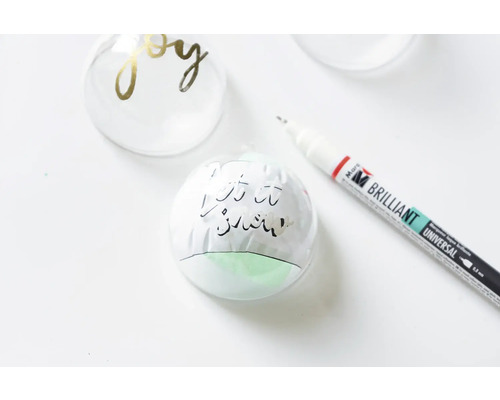 Dekorierte Weihnachtskugeln und ein Stift.