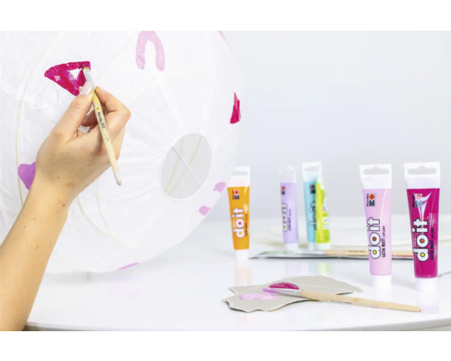 Bemalen einer Papierlaterne mit Farben und Pinsel