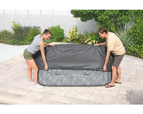 Aufblasbarer Whirlpool mit Abdeckung, im Garten von zwei Personen abgedeckt.