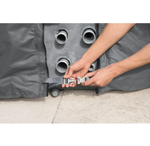 Person befestigt eine graue Abdeckung mit einem Klickverschluss.