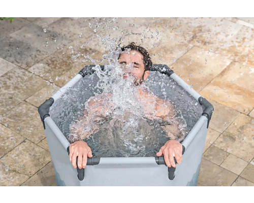Mann sitzt in einer Eiswanne mit Wasser