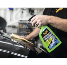 Detailer wird auf ein Auto gesprüht, im Hintergrund wischt eine Person die Oberfläche mit einem Tuch ab. Meguiars Logo.