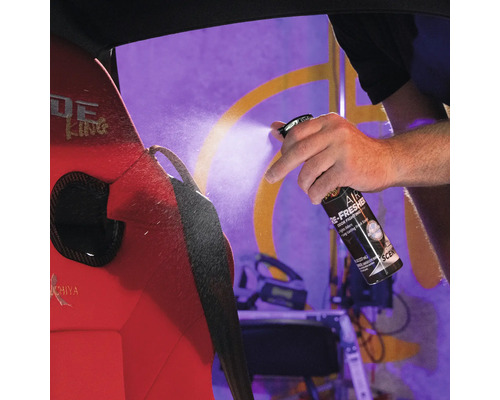 Eine Hand sprüht Lufterfrischer auf einen Autositz, um Gerüche zu bekämpfen und für einen lang anhaltenden, frischen Duft zu sorgen.