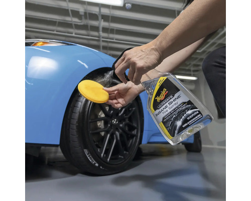Anwendung von Reifenspray auf ein Autorad mit Applikationsschwamm.