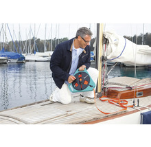 Mann hockt auf einem Boot und benutzt einen Schlauchwagen.