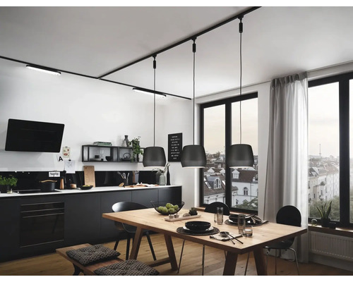 Küchenszene mit Esstisch, Beleuchtungssystem und Küchenmöbeln.