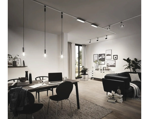 Wohnzimmer mit Esstisch, Sofa und Schienensystem mit Strahlern und Pendelleuchten.