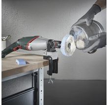 Bohrmaschine mit Polieraufsatz und Schraubstock am Werktisch beim Polieren eines Metalleimers