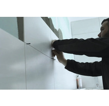 Fliesenleger bei der Arbeit mit Fliesen und Fliesenschnüren