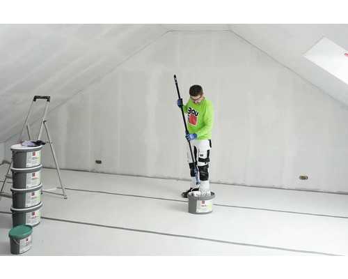 Ein Mann streicht einen Dachboden mit einer Farbrolle, Eimer mit Farbe und eine Leiter sind ebenfalls vorhanden