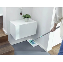 Reinigungskraft wischt Boden im Eingangsbereich mit einem Mopp