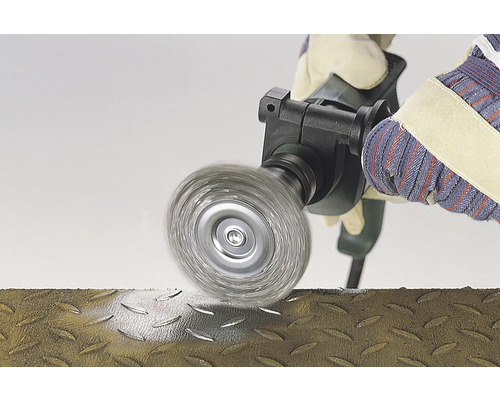 Drahtbürste im Einsatz auf einer Metalloberfläche, bedient von einer Person mit Handschuhen.