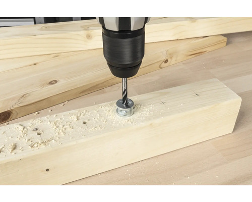 Bohrmaschine mit Forstnerbohrer beim Bohren eines Lochs in ein Holzbrett.