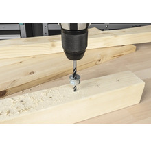 Akkubohrmaschine bohrt ein Loch in ein Holzbrett mit Tiefenanschlag