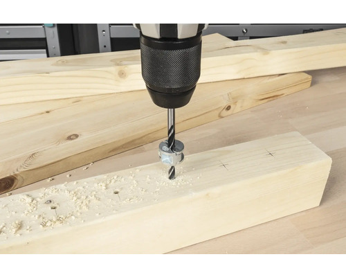 Akkubohrmaschine bohrt ein Loch in ein Holzbrett mit Tiefenanschlag