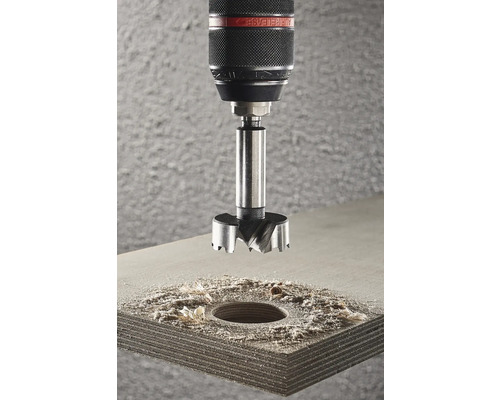 Forstnerbohrer mit Bohrmaschine bohrt Loch in Holzbrett