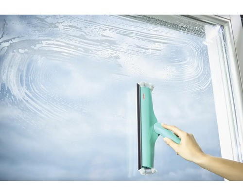 Hand wischt mit einem Fensterwischer eine Glasfläche sauber