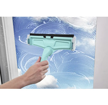 Fensterreiniger im Einsatz auf einer Glasoberfläche