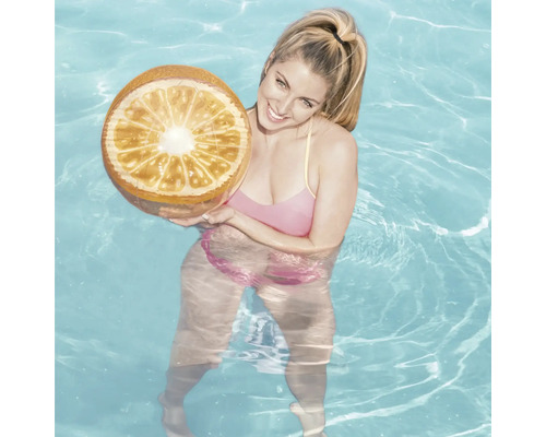 Frau im Schwimmbad mit einer aufblasbaren Orange