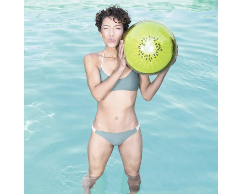 Frau im Schwimmbad hält einen aufblasbaren Kiwi-Ball