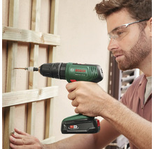 Mann schraubt mit einem Akku-Schlagschrauber von Bosch eine Schraube in eine Holzkonstruktion