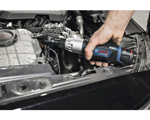 Eine Person benutzt einen Akku-Drehschlagschrauber von Bosch Professional am Motor eines Autos.