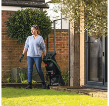 Frau im Garten mit einem Gartenhäcksler der Marke Bosch