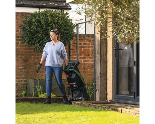 Frau im Garten mit einem Gartenhäcksler der Marke Bosch