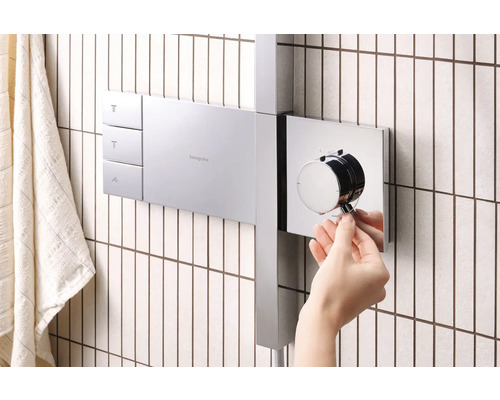 Aufputz Duscharmatur mit Hand die Temperatur einstellt.