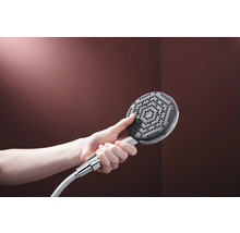 Hand hält Duschkopf mit Brauseschlauch