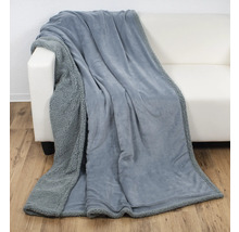 Graue Kuscheldecke auf einem weißen Sofa