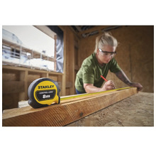 Frau misst Holz mit einem Stanley Rollbandmaß mit 8 Metern Länge