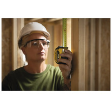 Frau misst mit einem Stanley Rollbandmass 8 m in einem Holzrahmenbau