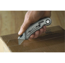 Eine Hand schneidet mit einem Stanley-Messer einen Karton auf.