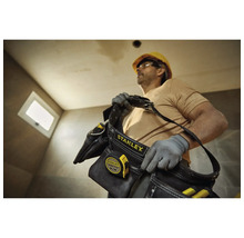 Handwerker mit Stanley Werkzeugtasche und Messband auf einer Baustelle