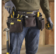 Handwerker mit Werkzeuggürtel der Marke Stanley, ausgestattet mit verschiedenen Werkzeugen