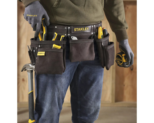 Handwerker mit Werkzeuggürtel der Marke Stanley, ausgestattet mit verschiedenen Werkzeugen