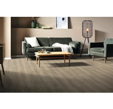 Wohnzimmer mit Sofa, Sessel, Tisch, Stehlampe und Holzboden