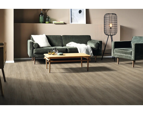 Wohnzimmer mit Sofa, Sessel, Tisch, Stehlampe und Holzboden