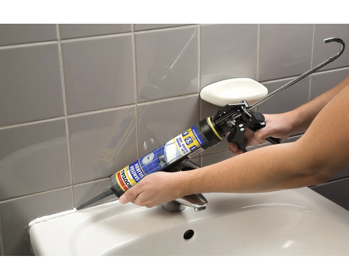 Auftragen von Sanitärsilikon mit einer Kartuschenpistole in einem Badezimmer