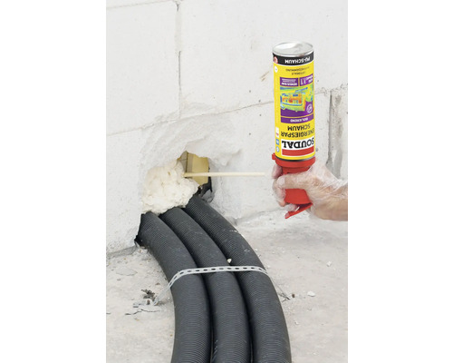 Isolierung eines Mauerdurchbruchs mit Montageschaum und Kabelschutzrohren
