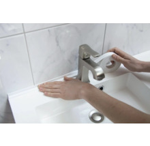 Anbringen eines weißen Dichtungsbands an einem Waschbecken im Badezimmer.