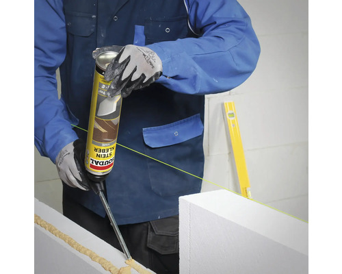 Ein Arbeiter verwendet Stein Kleber für Bauarbeiten.